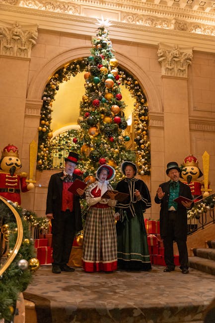 Victorian-dressed carolers perform by an ornate Christmas tree indoors.